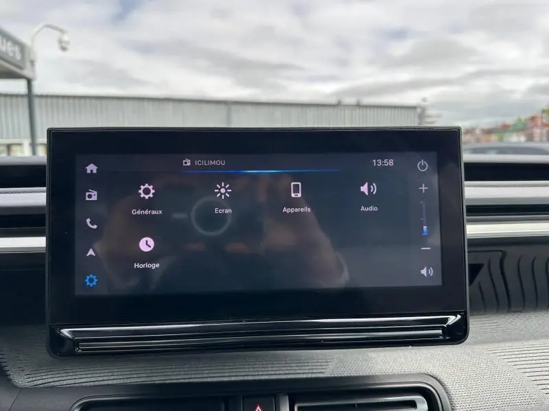 Écran tactile central du tableau de bord de la Citroën C3 électrique 2025, affichant les réglages généraux et audio.