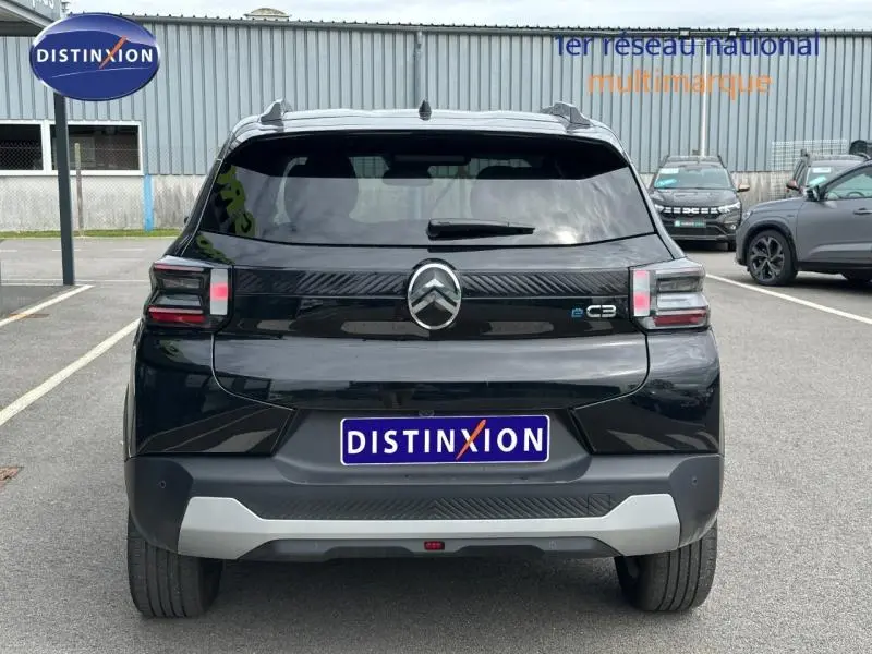 Vue arrière d'une Citroën C3 électrique 2025 en noir Perla Nera avec logo et badge e-C3 visibles.