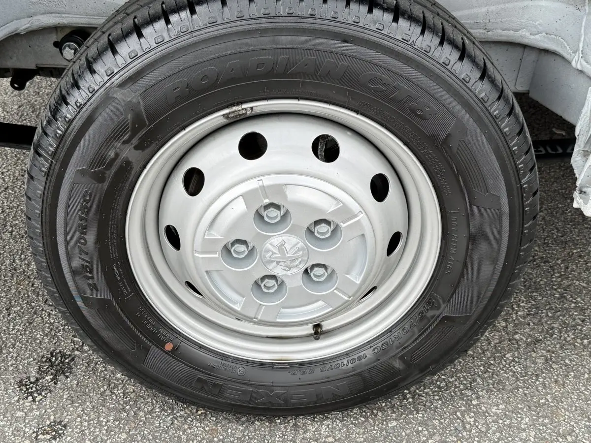 Gros plan sur la roue avant droite du Peugeot Boxer Fourgon blanc, mettant en valeur la jante acier et le pneu Nexen Roadian.