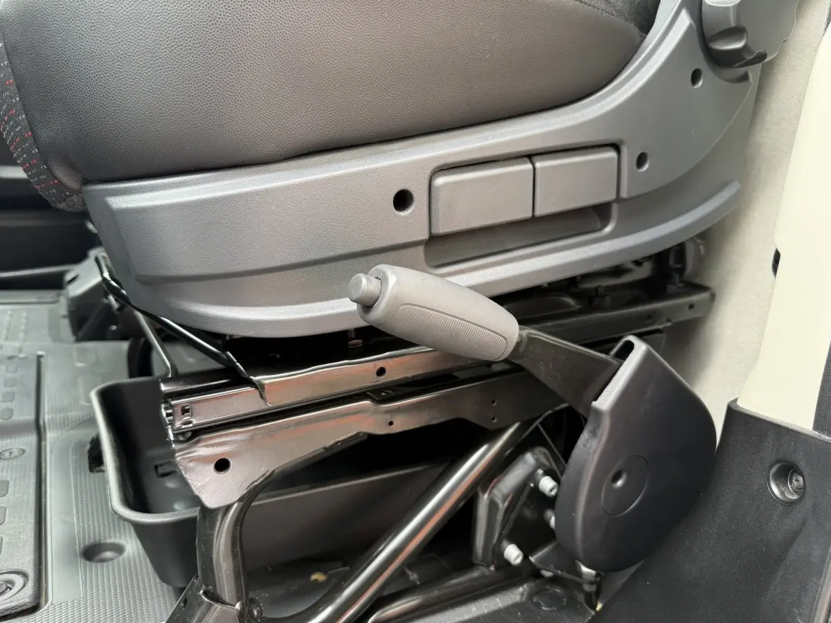 Détail de la manette de réglage du siège côté conducteur du Peugeot Boxer Fourgon blanc, vue rapprochée intérieure.