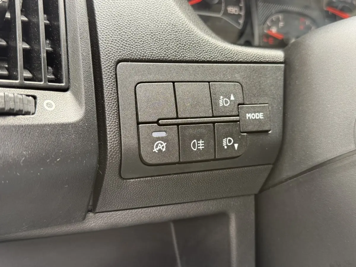Gros plan sur les commandes d'éclairage et mode du tableau de bord du Peugeot Boxer Fourgon blanc, version 2023.