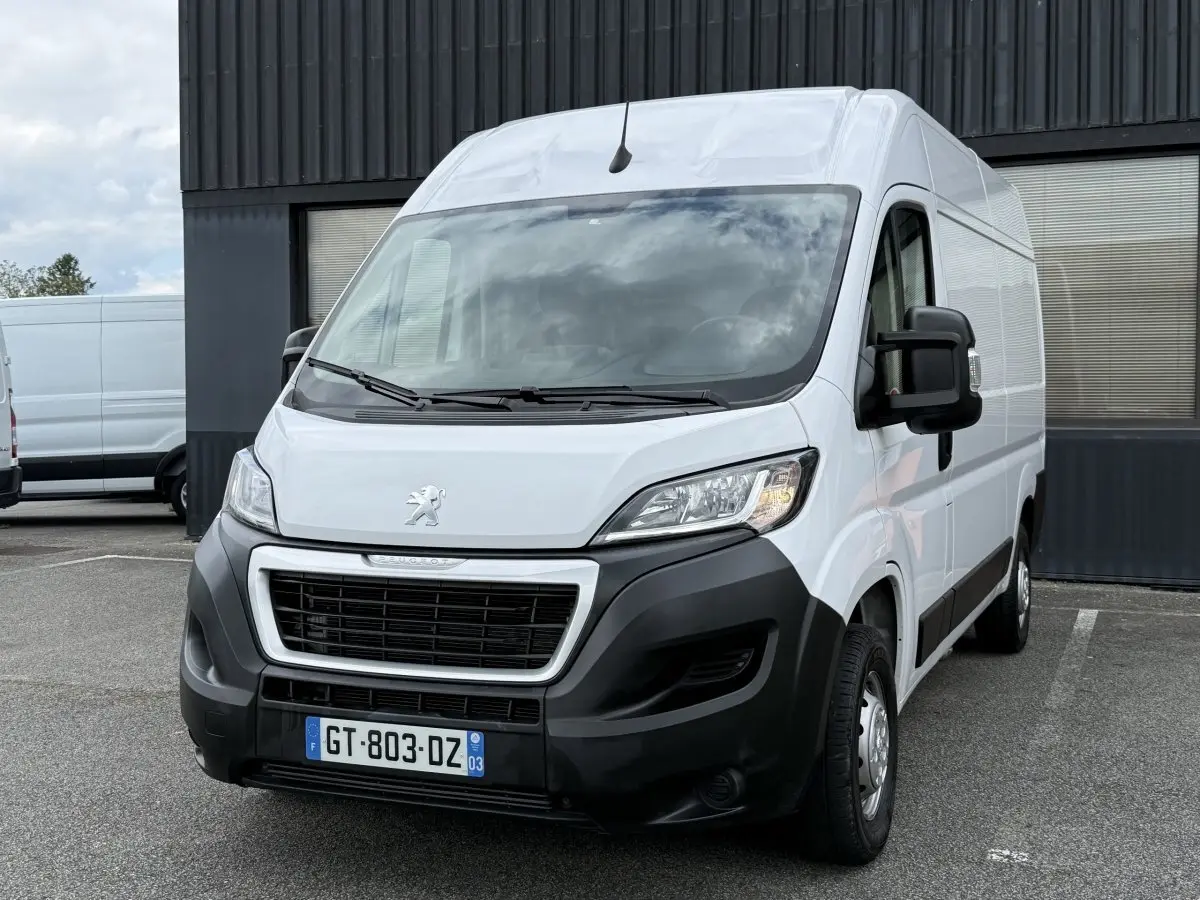 Vue 3/4 avant droit d’un Peugeot Boxer Fourgon blanc avec calandre noire et pare-chocs noir mat.