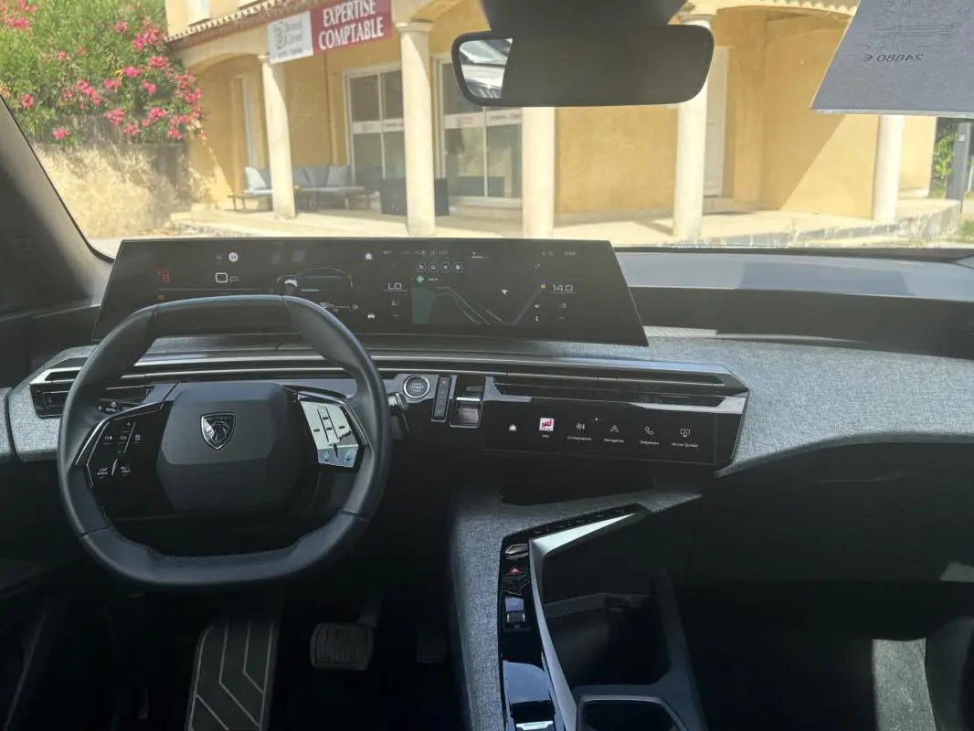 Vue intérieure du tableau de bord du Peugeot 3008 Hybrid 136 e-DCS6 Allure 2025 noir, avec volant compact et double écran numérique.