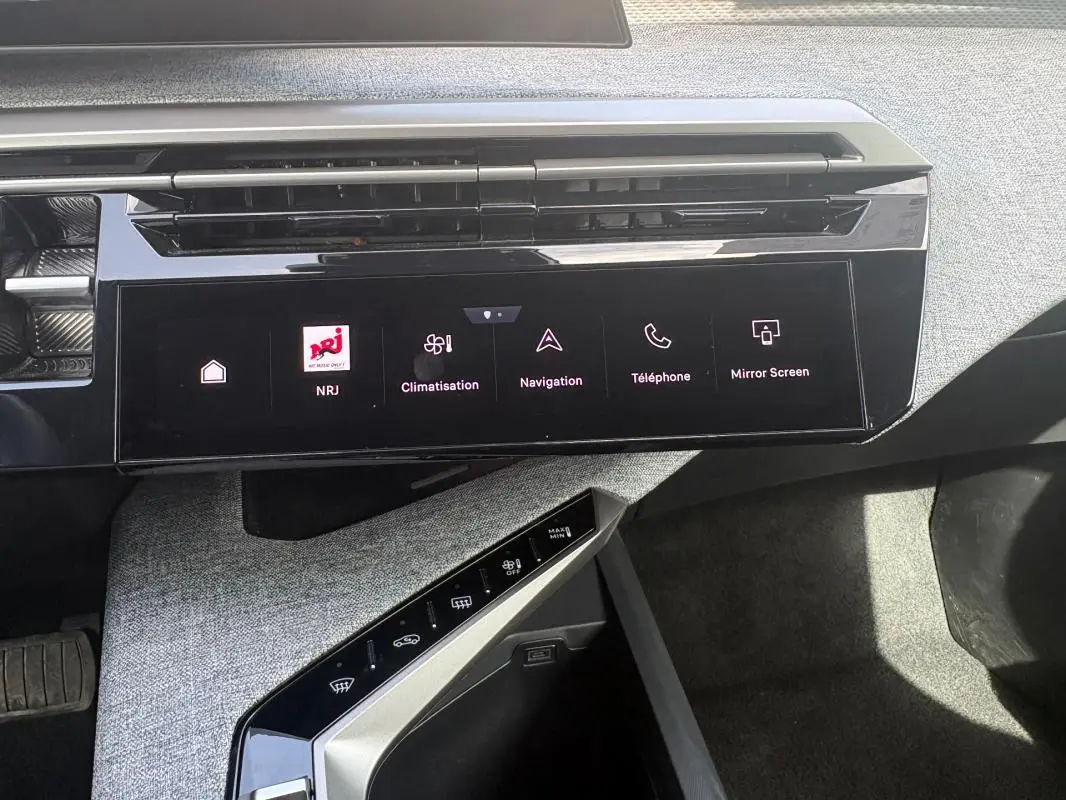 Vue rapprochée de la console centrale du Peugeot 3008 Hybrid noir, avec écran tactile et commandes climatisation.