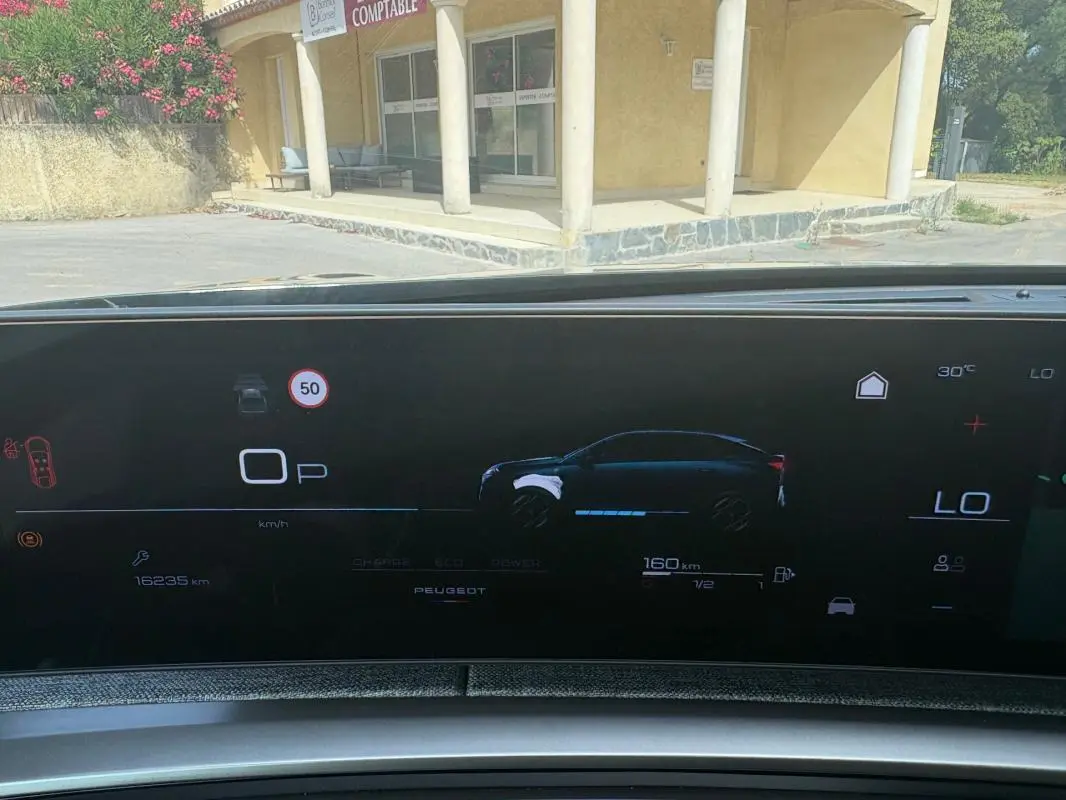 Affichage numérique du cockpit du Peugeot 3008 Hybrid 136 e-DCS6 Allure montrant l'autonomie et la vitesse, vue intérieure frontale.