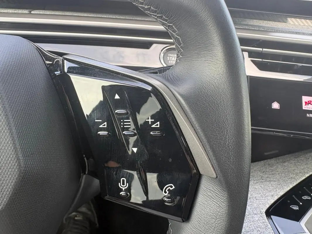 Gros plan sur le volant noir du Peugeot 3008 Hybrid 136 e-DCS6 Allure avec commandes tactiles intégrées.