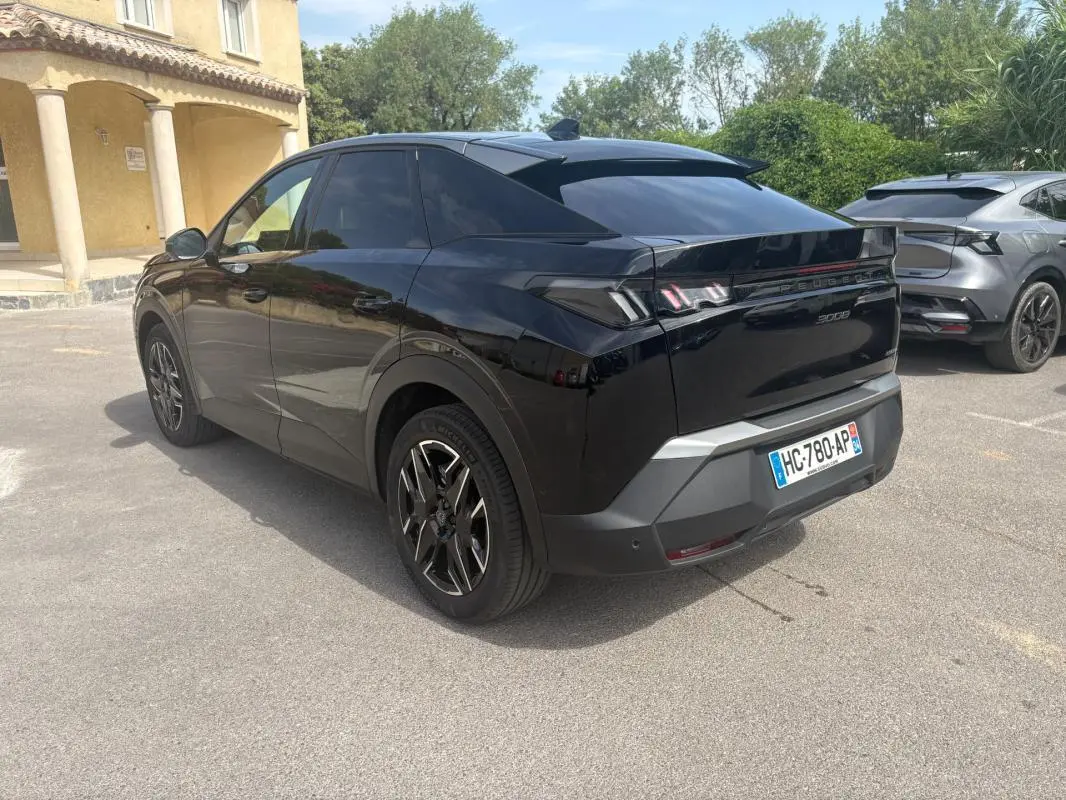 Peugeot 3008 Hybrid noir en 3/4 arrière droit, jantes alliage 19 pouces et feux arrière distinctifs allumés.