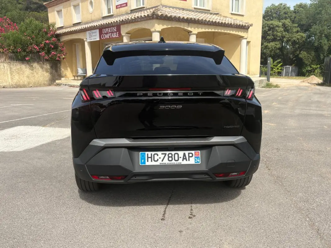 Vue arrière d’un Peugeot 3008 Hybrid noir 2025 avec feux distinctifs à triple griffes et plaque d’immatriculation française.