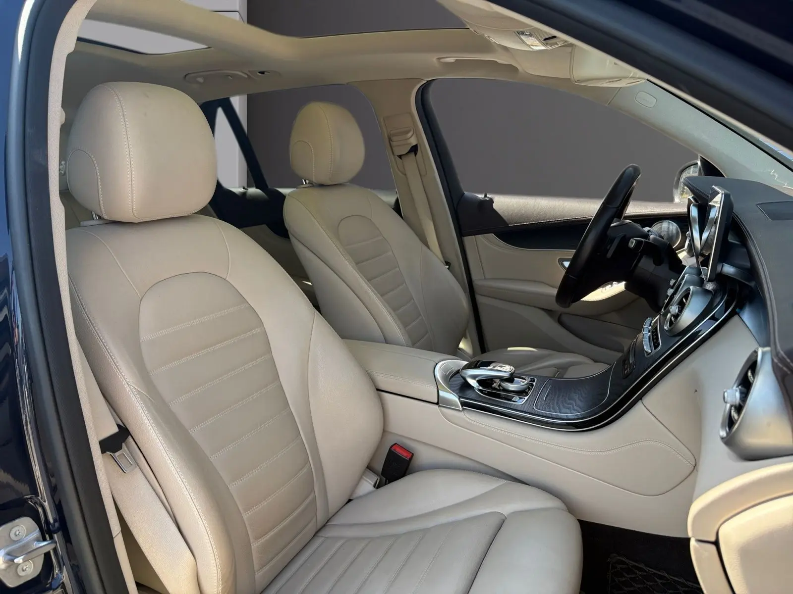 Vue intérieure côté gauche du Mercedes GLC 350 E Hybrid Fascination 2017, sièges cuir beige et tableau de bord noir.