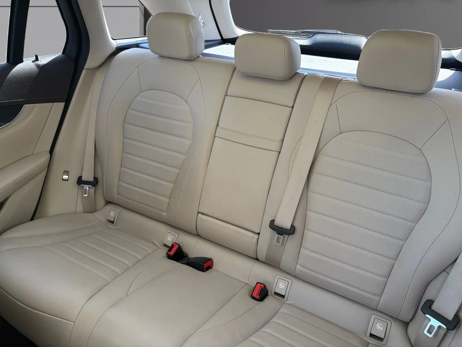 Vue intérieure arrière des sièges en cuir beige du Mercedes GLC 350 E Hybrid Fascination 2017, avec ceintures visibles.