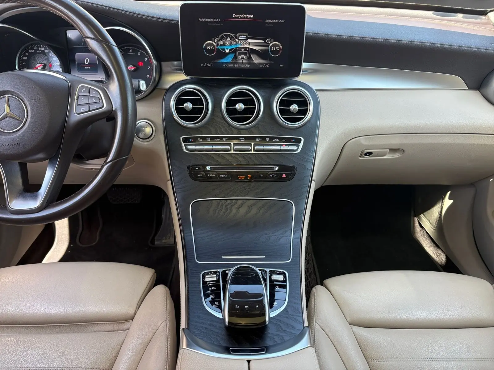 Vue intérieure centrée sur la console centrale et le volant cuir noir du Mercedes GLC 350 E Hybrid Fascination 2017.