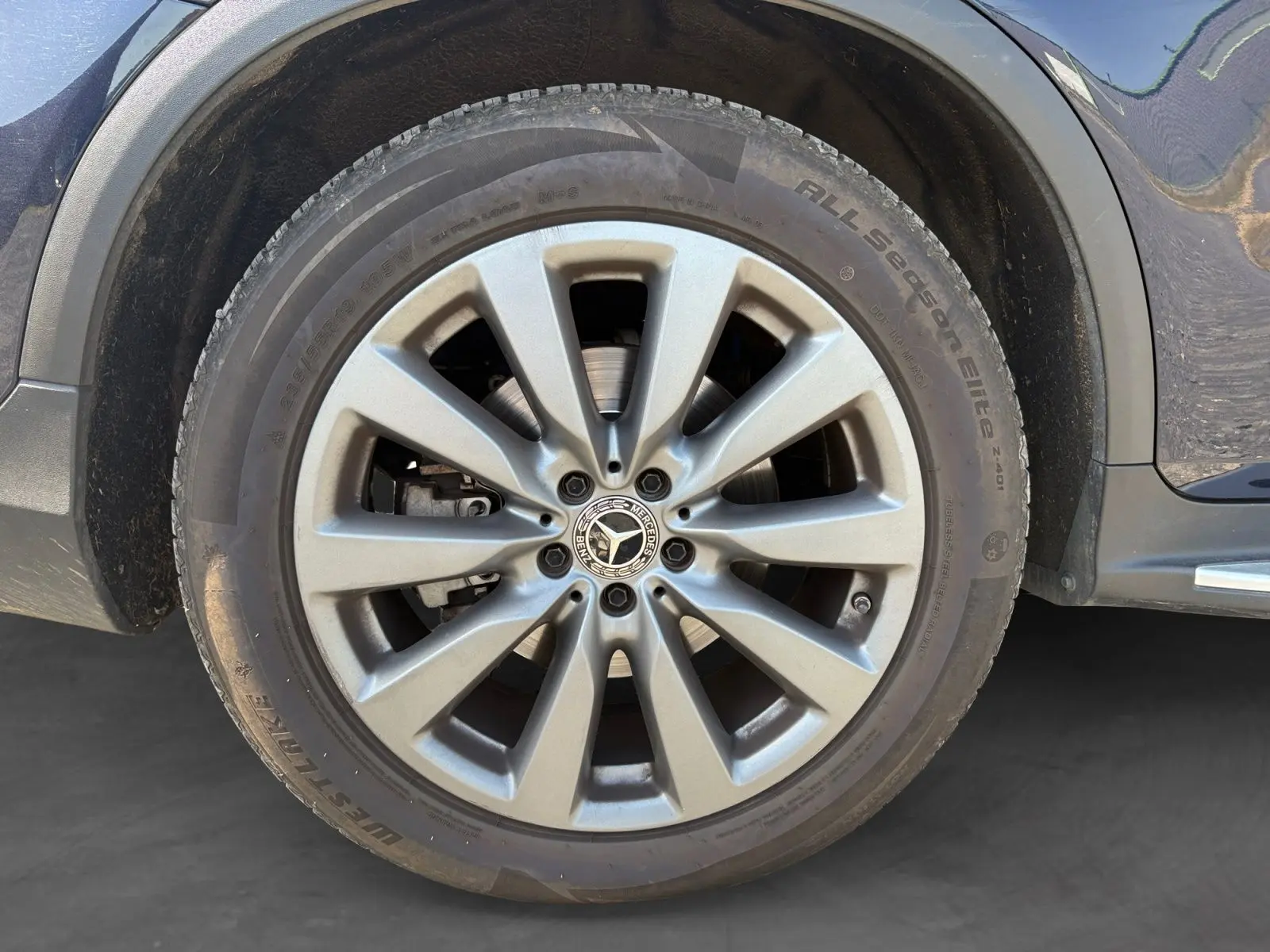 Gros plan sur la jante alliage 19 pouces argentée du côté gauche d’un Mercedes GLC bleu 350 E Hybrid.