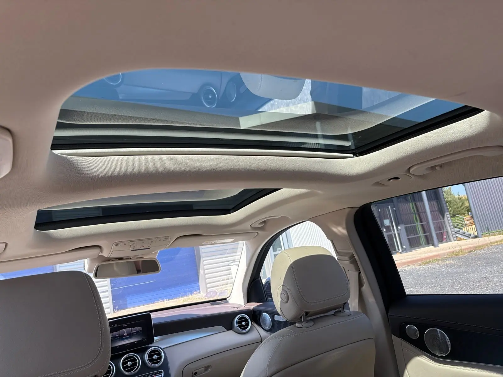 Vue intérieure du toit ouvrant panoramique et tableau de bord clair d'une Mercedes GLC 350 E Hybrid Fascination 2017.