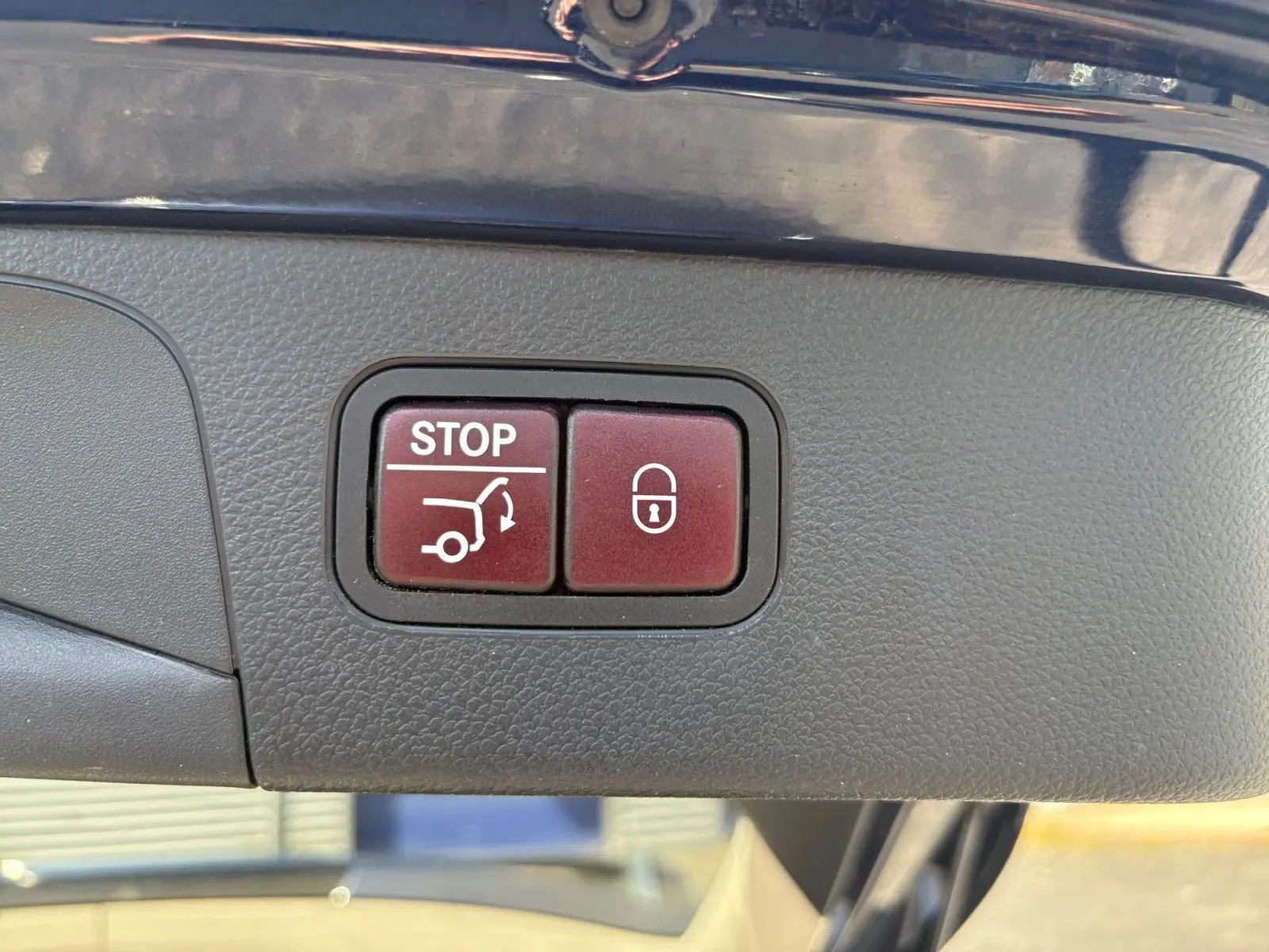Gros plan sur les boutons de hayon électrique et verrouillage, intérieur d'un Mercedes GLC 350 E Hybrid bleu 2017.