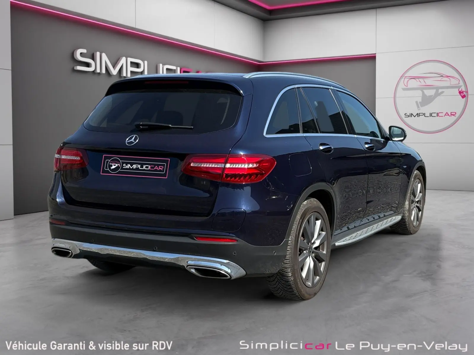 Vue 3/4 arrière droite d'un Mercedes GLC 350 E Hybrid Fascination bleu avec jantes alliage et sorties d'échappement chromées.