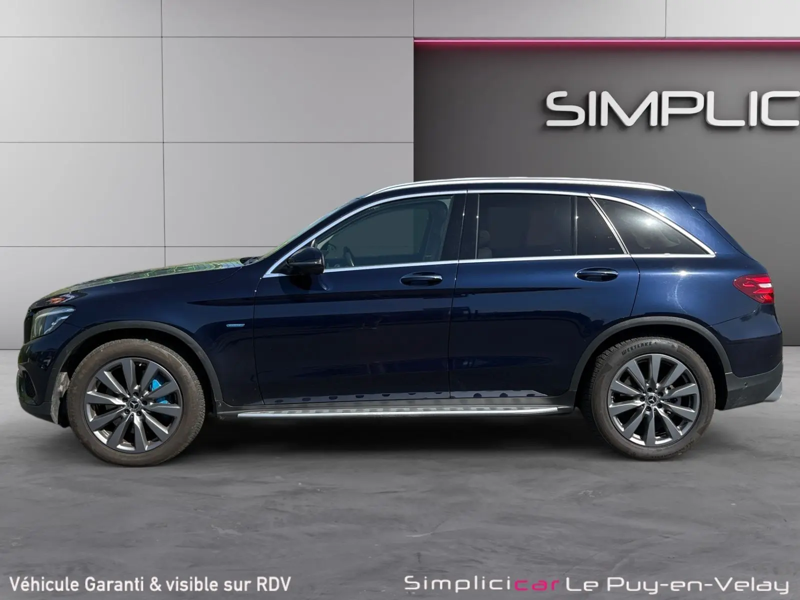 Vue de profil côté gauche d'un Mercedes GLC 350 E Hybrid Fascination bleu avec jantes alliage 19 pouces.