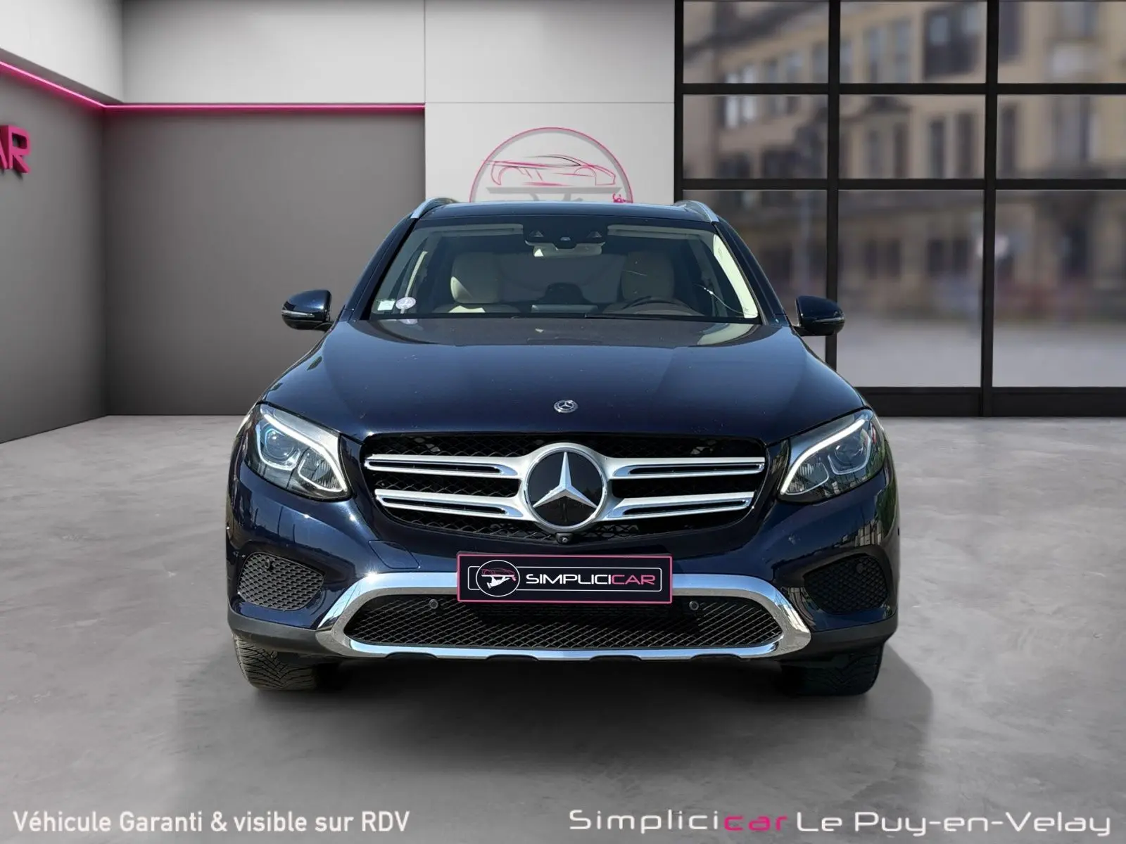 Vue avant d’un Mercedes GLC 350 E Hybrid Fascination bleu avec calandre chromée et phares LED allumés.