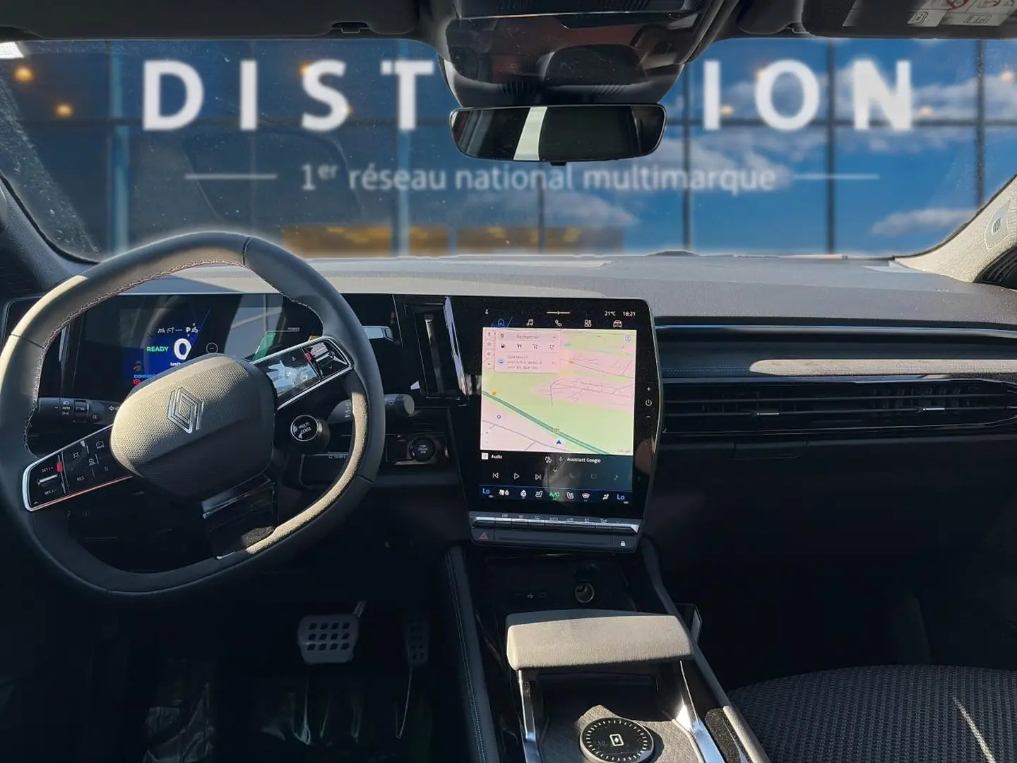 Vue intérieure avant du Renault Austral noir 2026, tableau de bord moderne avec écran tactile central et volant multifonction.