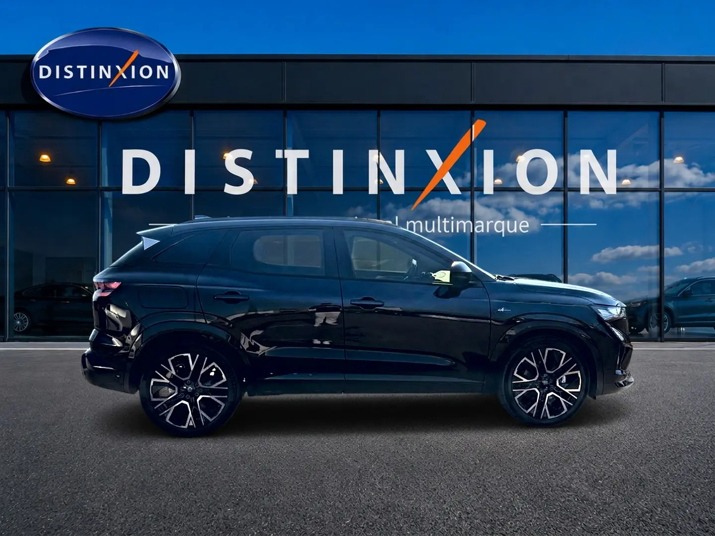 Profil côté gauche du Renault Austral noir 1.2 e-tech full hybrid 200 esprit alpine avec jantes alu distinctives.