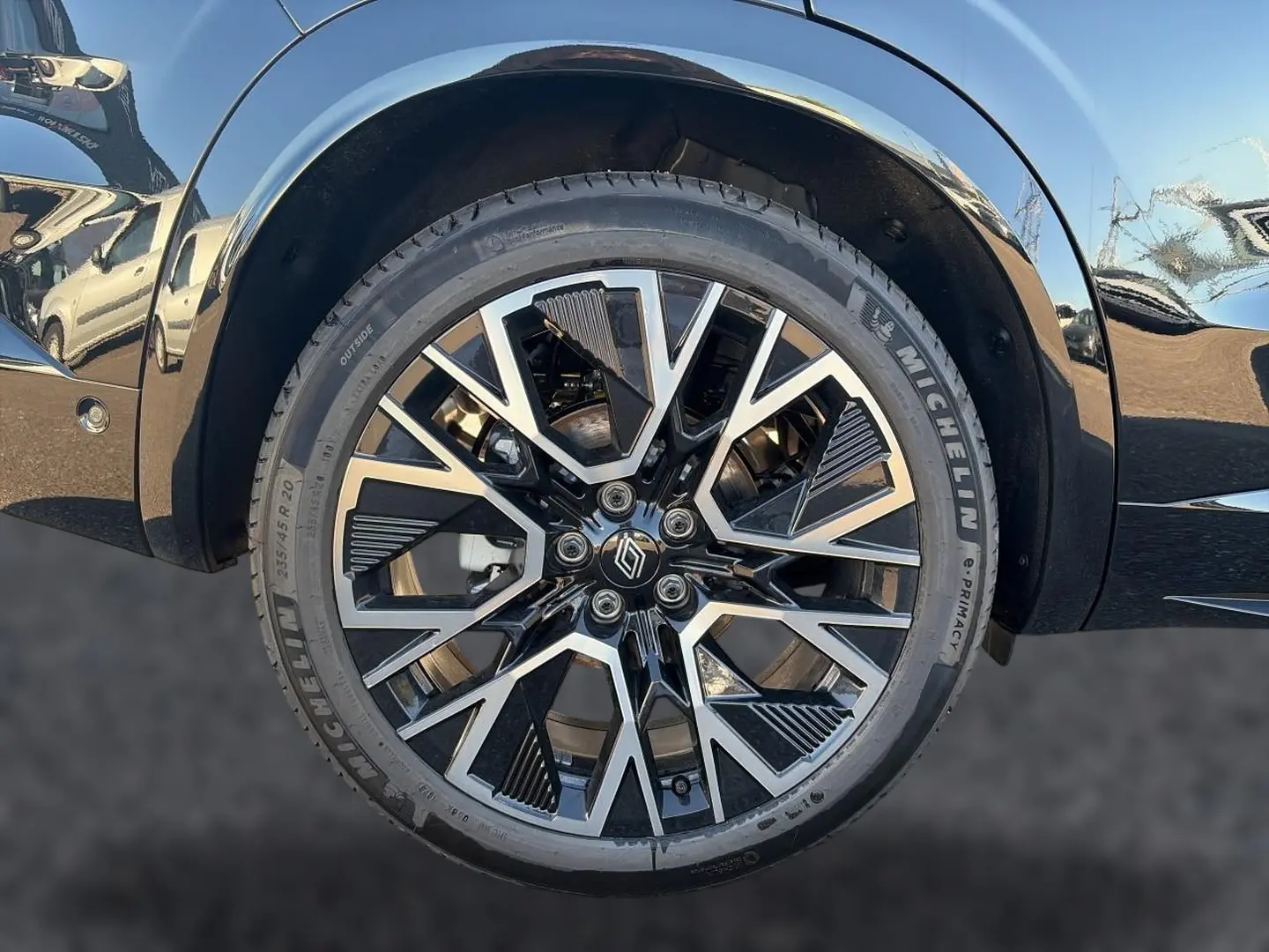 Gros plan sur la roue avant droite noire du Renault Austral 1.2 e-tech full hybrid avec jante alu bicolore design géométrique.
