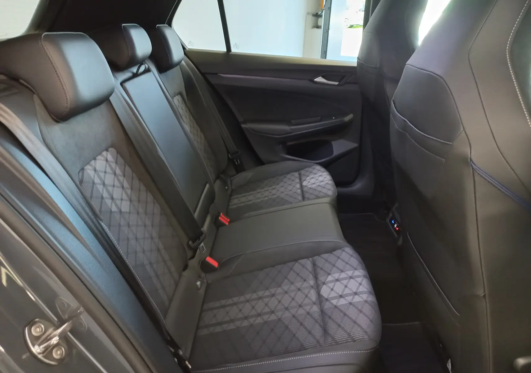 Vue intérieure côté gauche des sièges arrière en tissu et cuir noir de la Volkswagen Golf 1.5 eTSI R-Line Gris Dauphin 2025.