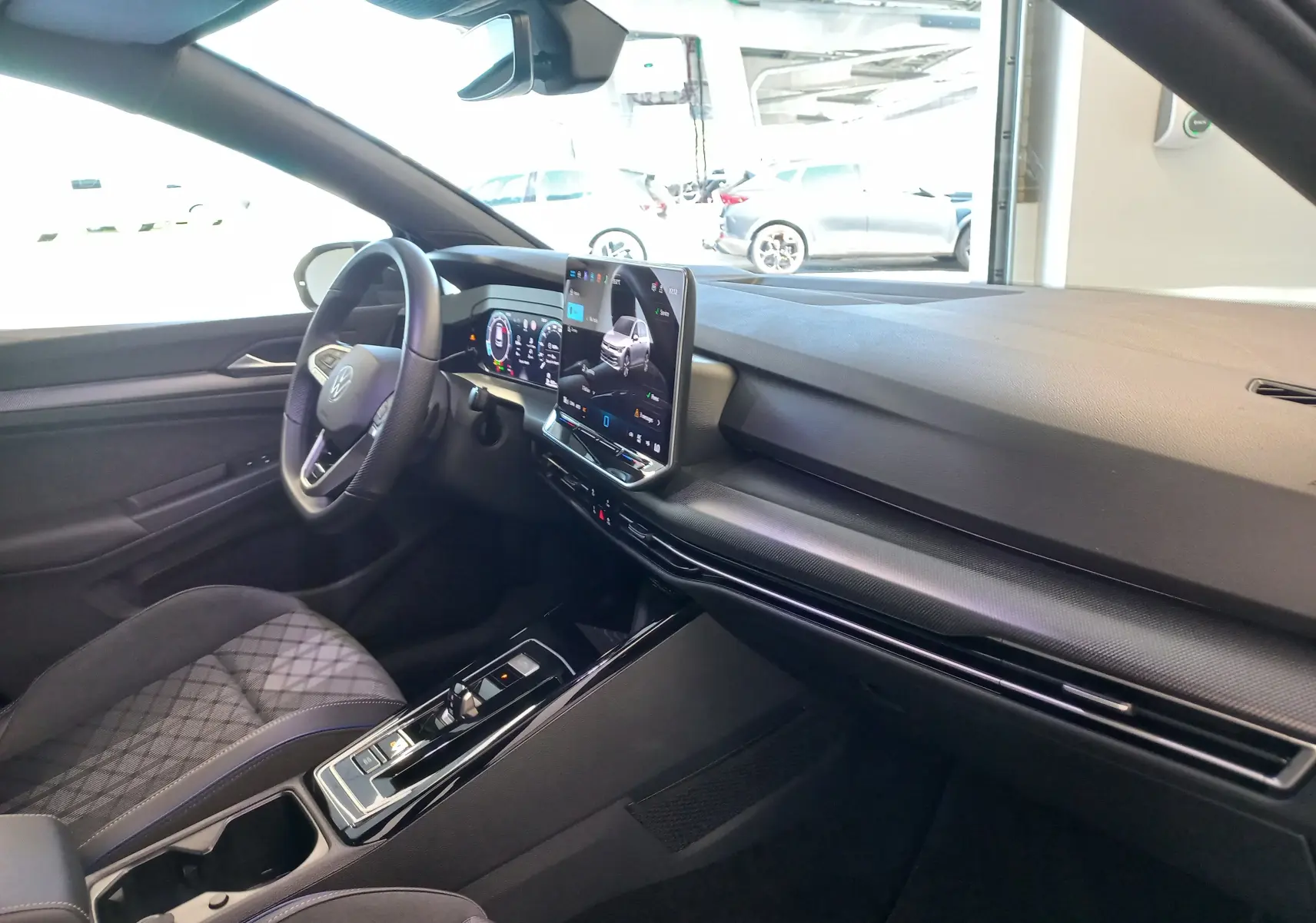 Vue intérieure côté conducteur de la Volkswagen Golf 1.5 eTSI R-Line 2025 avec tableau de bord numérique et écran tactile central.
