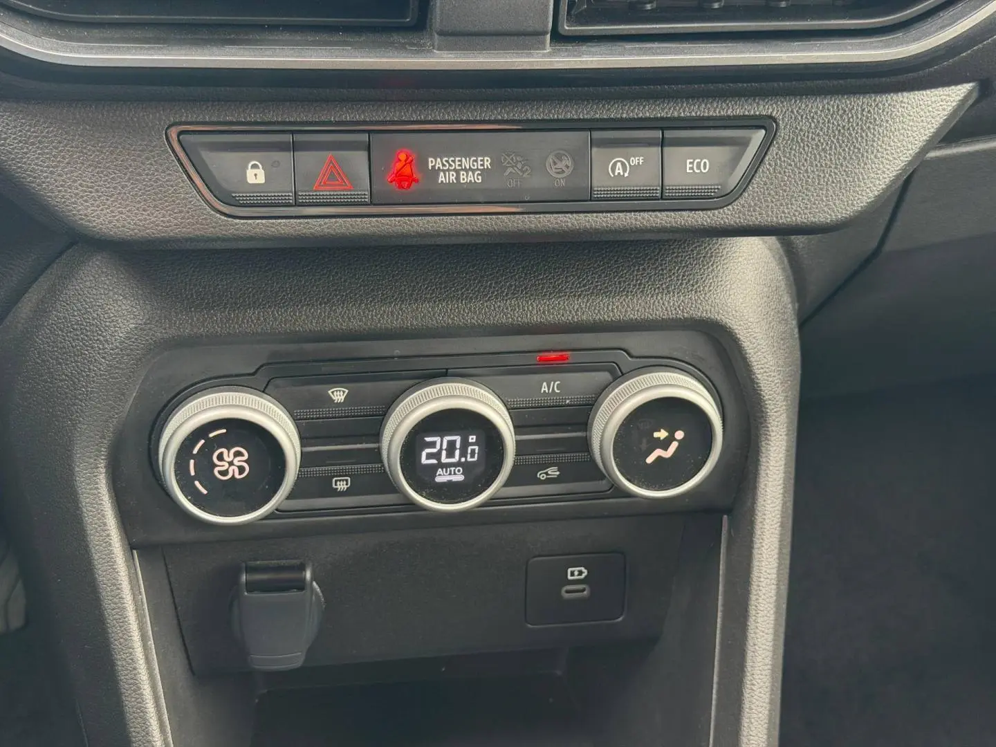 Détail de la console centrale du Dacia Jogger 2025 montrant les commandes de climatisation automatique et les voyants de sécurité.