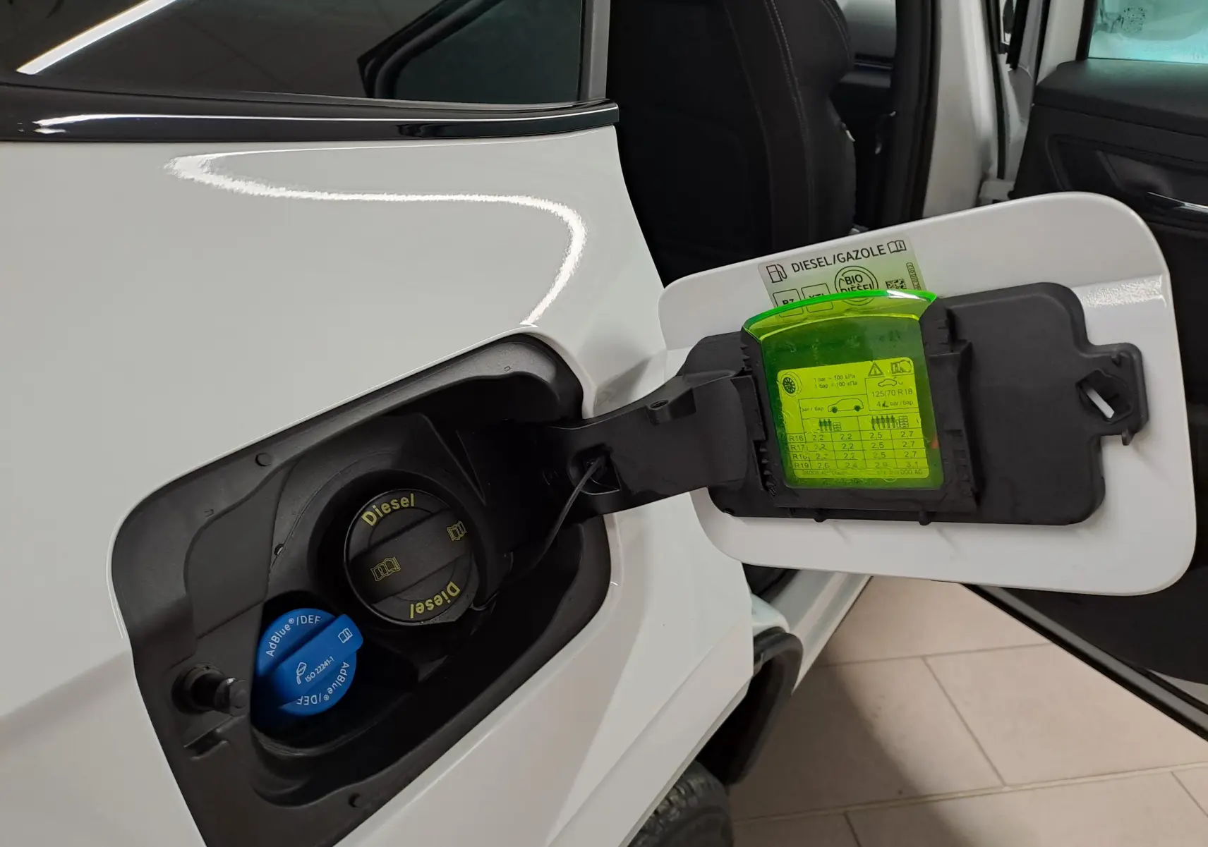 Vue rapprochée du bouchon de réservoir diesel ouvert côté gauche d’un Skoda Karoq Blanc Lune 2022 Sportline.