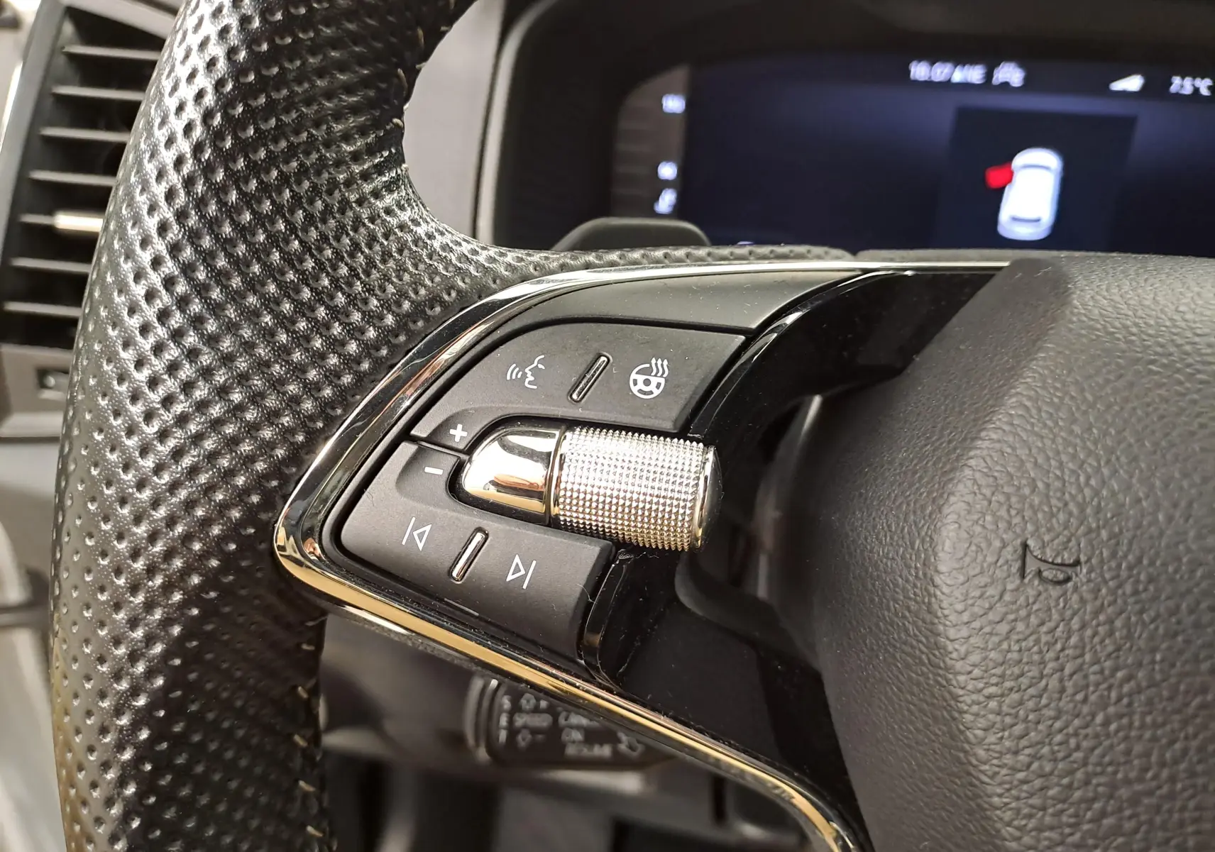 Gros plan sur les commandes gauche du volant en cuir perforé du Skoda Karoq 2.0 TDI 116 DSG7 Sportline 2022.