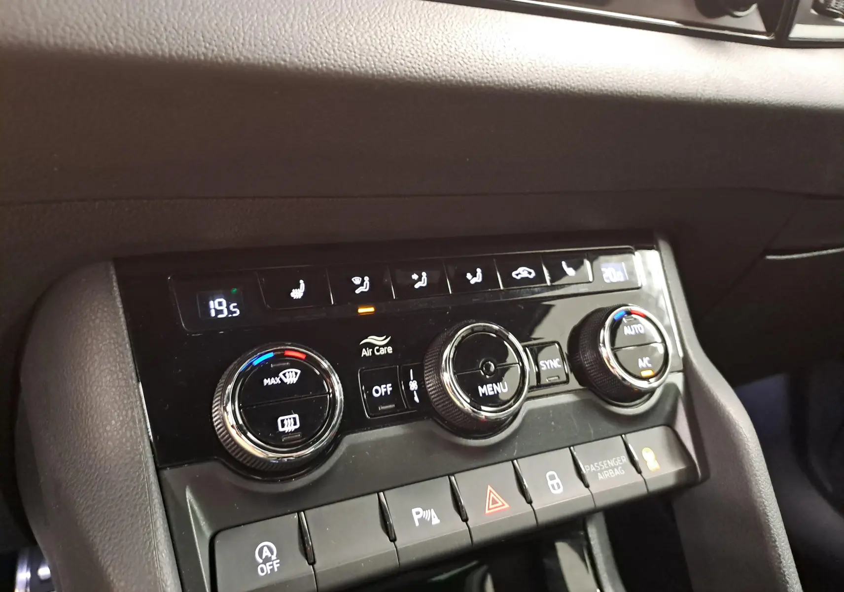 Gros plan sur la console centrale du Skoda Karoq 2022, montrant les commandes de climatisation et les boutons de fonction.