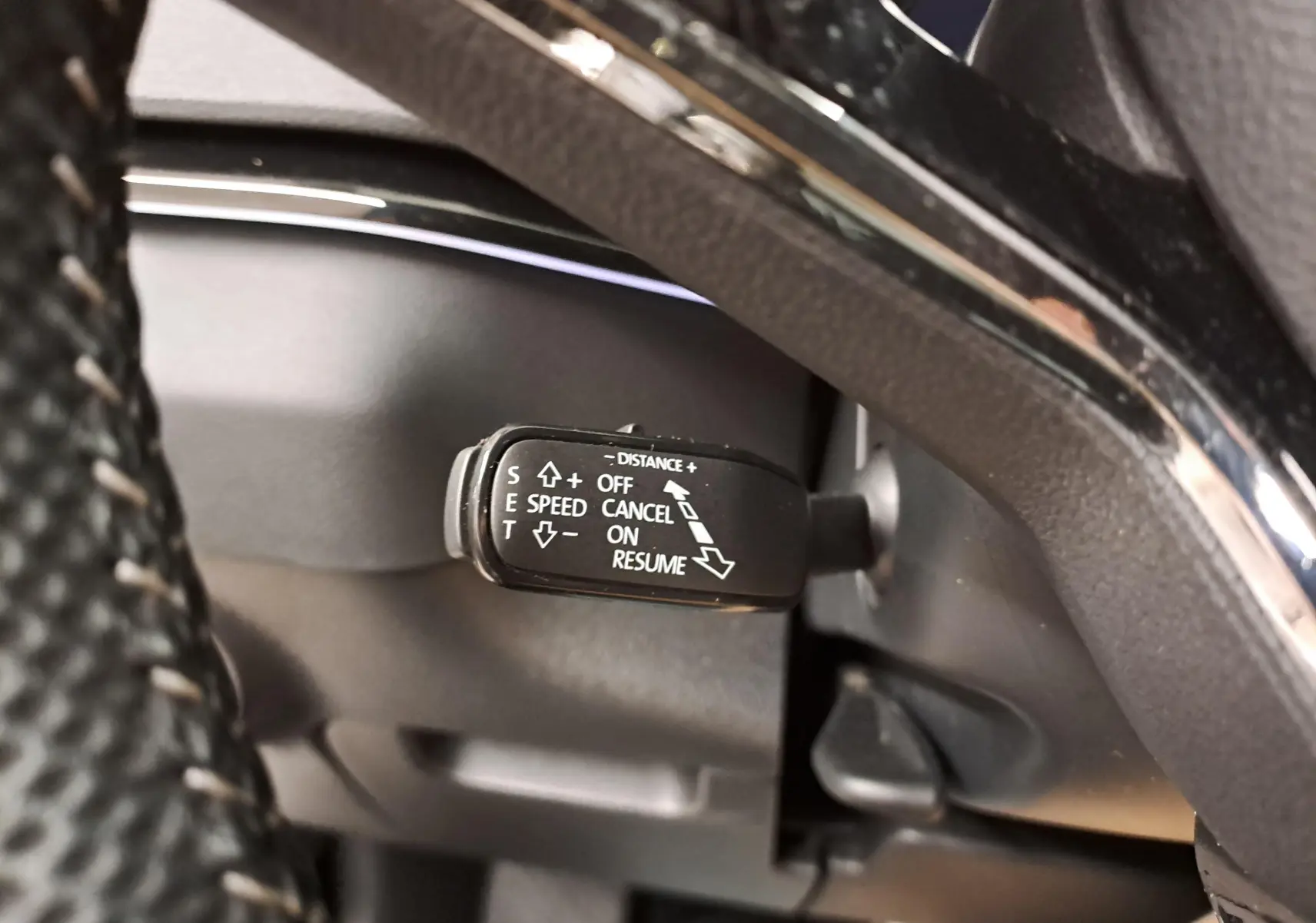 Gros plan sur la commande de régulateur de vitesse du Skoda Karoq 2.0 TDI 116 DSG7 Sportline, intérieur noir.