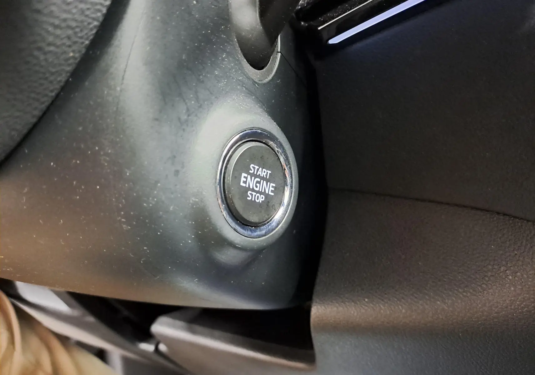 Bouton start/stop moteur en gros plan sur le tableau de bord noir du Skoda Karoq 2.0 TDI 116 DSG7 Sportline 2022.