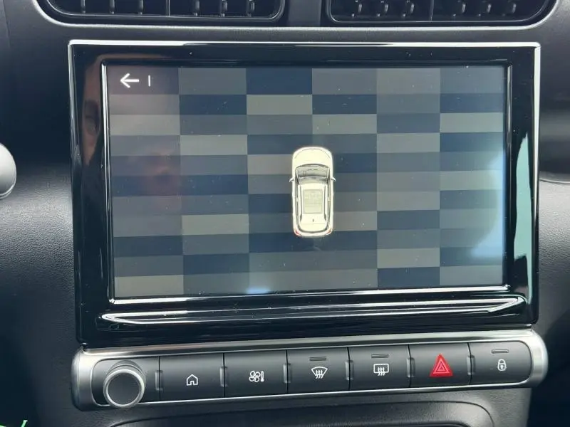 Écran tactile central affichant une vue de dessus du véhicule dans un intérieur noir du Citroën C3 Aircross blanc.
