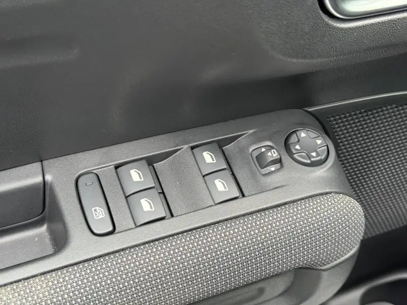 Gros plan sur les commandes des vitres et rétroviseurs côté conducteur du Citroën C3 Aircross blanc Banquise 2024.
