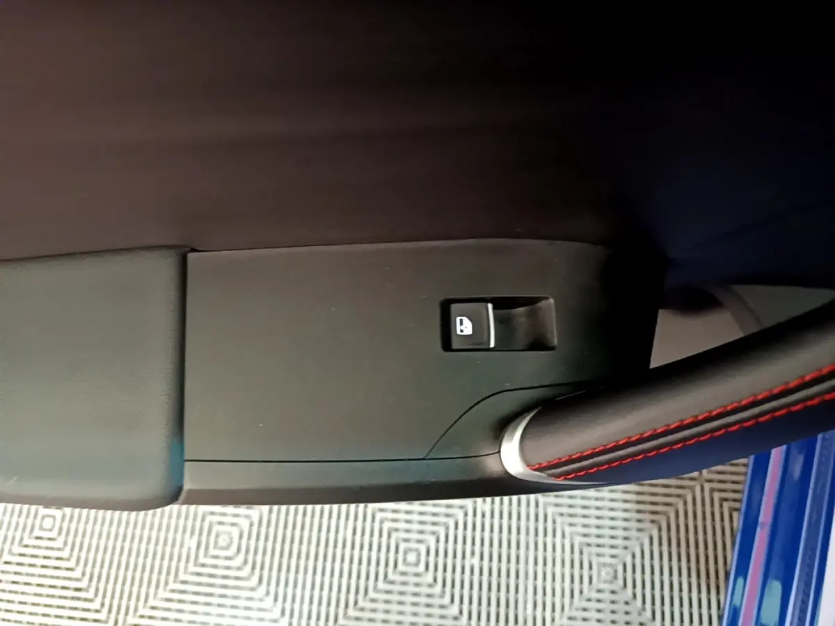 Détail de la commande de verrouillage sur la porte côté conducteur d’une SEAT Leon bleu 1.5 eTSI 150 DSG S&S FR 2021.