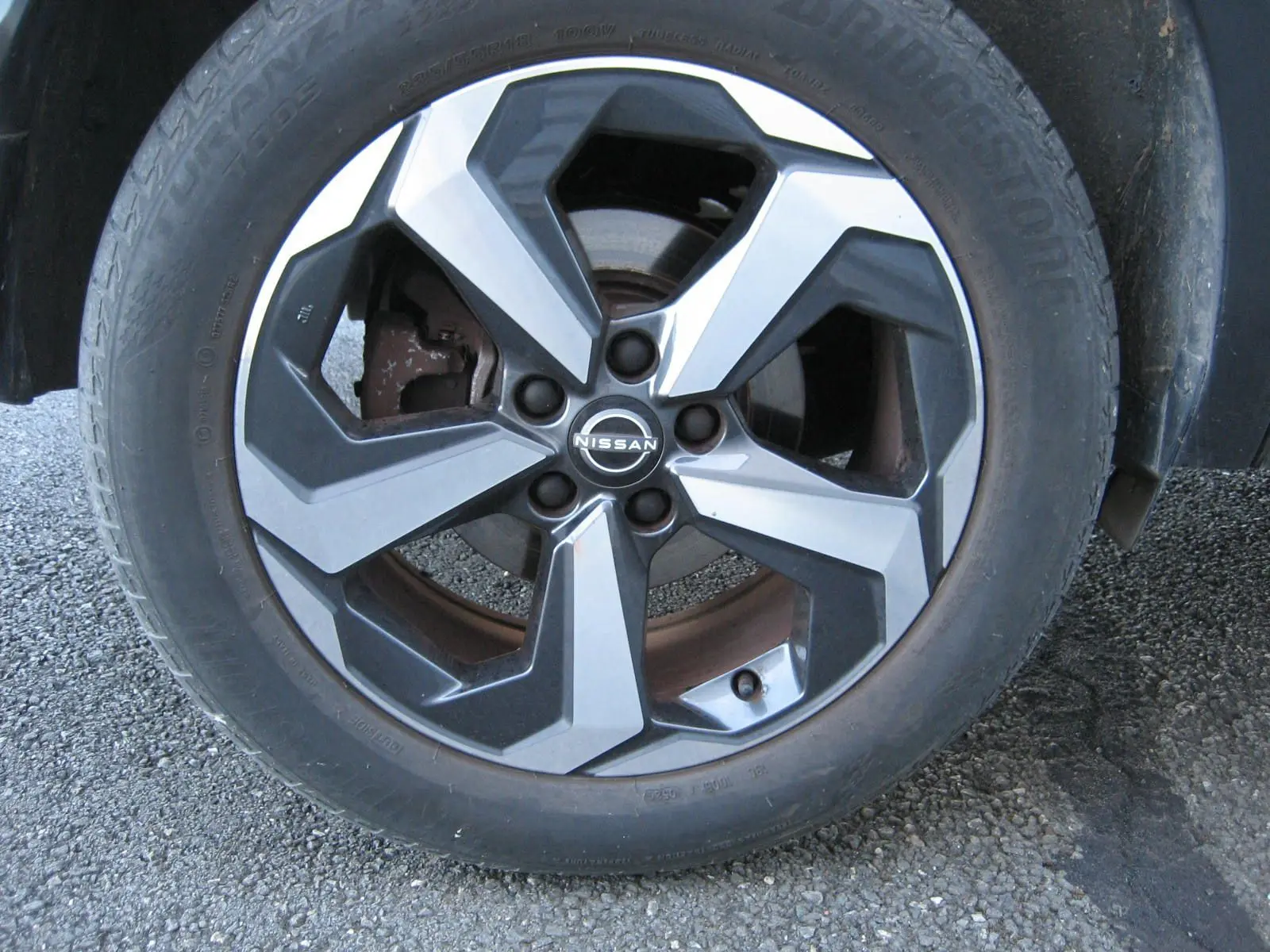 Gros plan sur la jante bi-ton noir et argent du Nissan Qashqai E-POWER 2024 avec logo central visible.