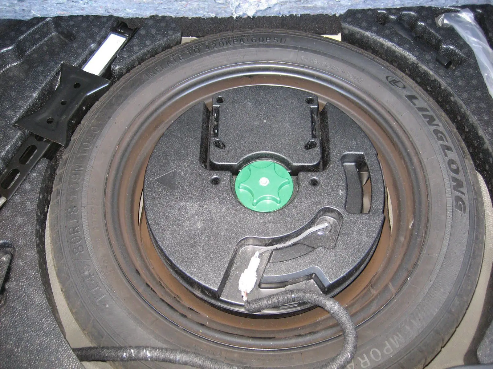 Roue de secours et kit de réparation dans le coffre du Nissan Qashqai blanc nacré 2024, vue plongeante.