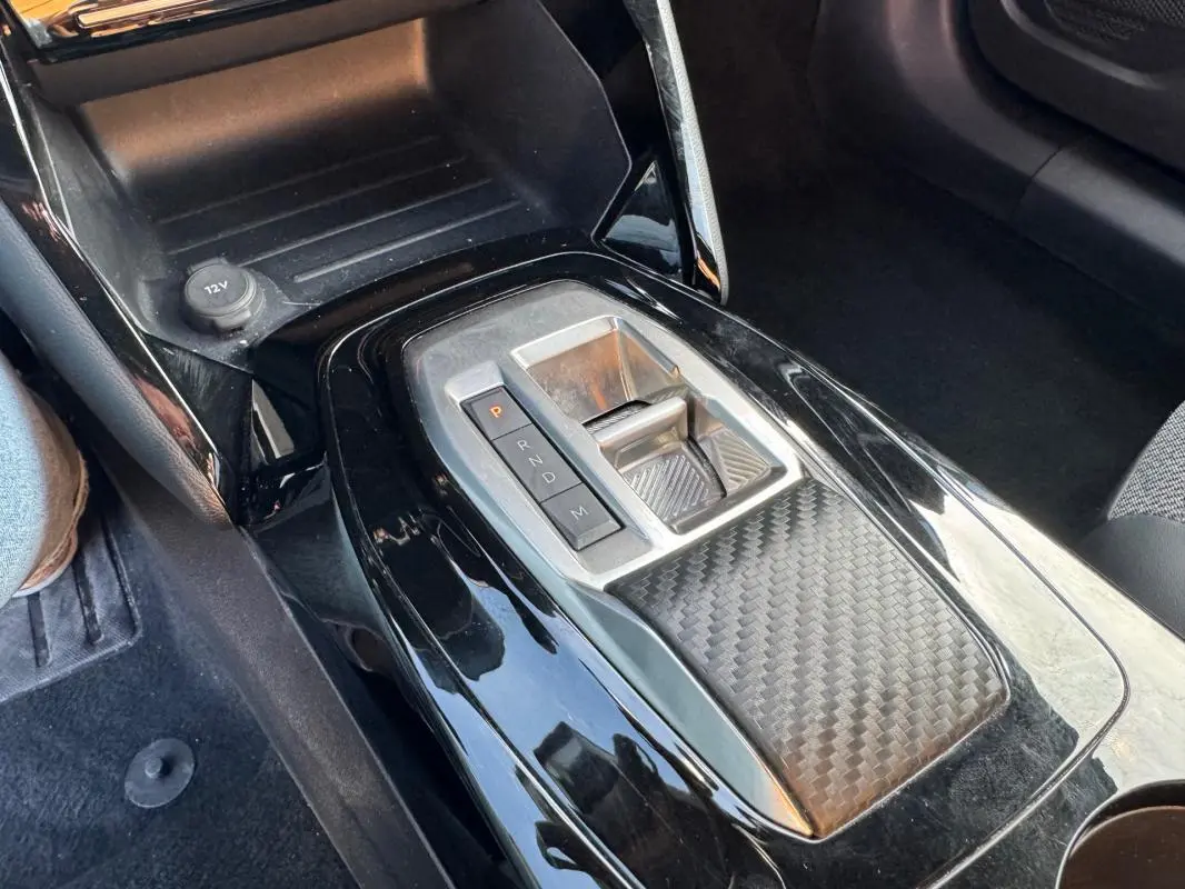 Gros plan sur la console centrale noire de la Peugeot 2008 Hybrid 136 e-DCS6 Allure avec levier de vitesses automatique.