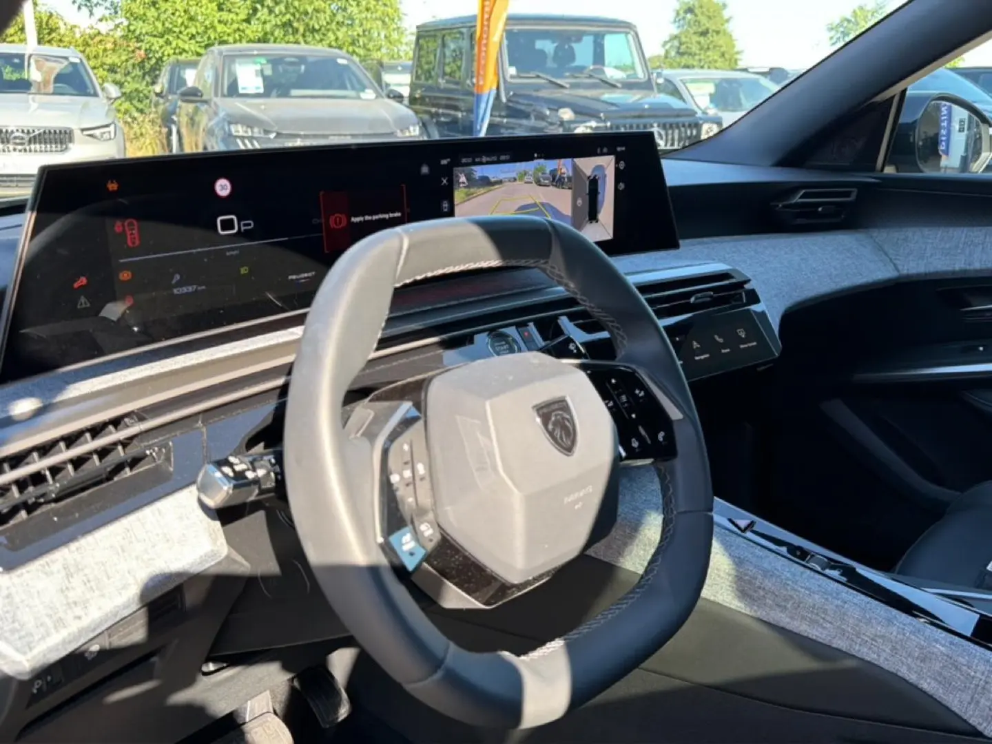 Vue intérieure du volant cuir et tableau de bord numérique du Peugeot 3008 1.2 hybrid 145 allure 2025.