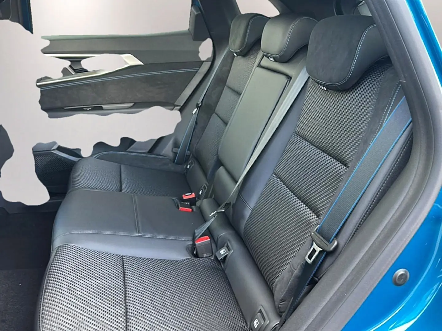 Vue côté droit des sièges arrière en tissu carbone alcantara noir avec surpiqûres bleues sur un Renault Austral bleu outremer.