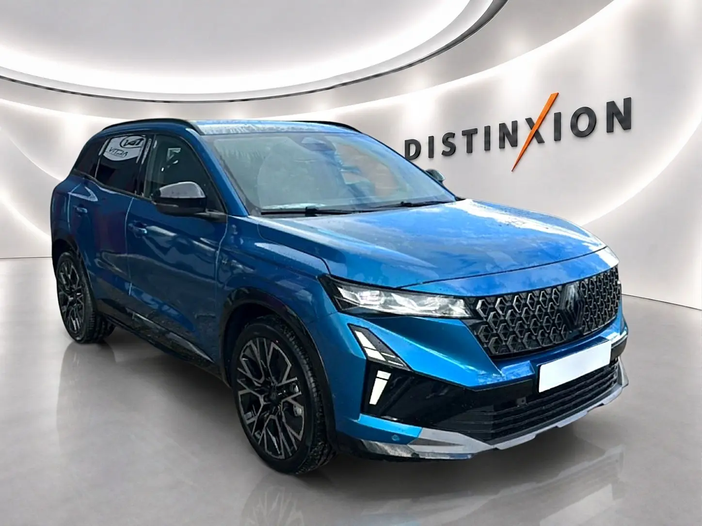 Renault Austral 2026 bleu outremer en 3/4 avant droit, avec calandre noire et jantes alliage noires distinctives.