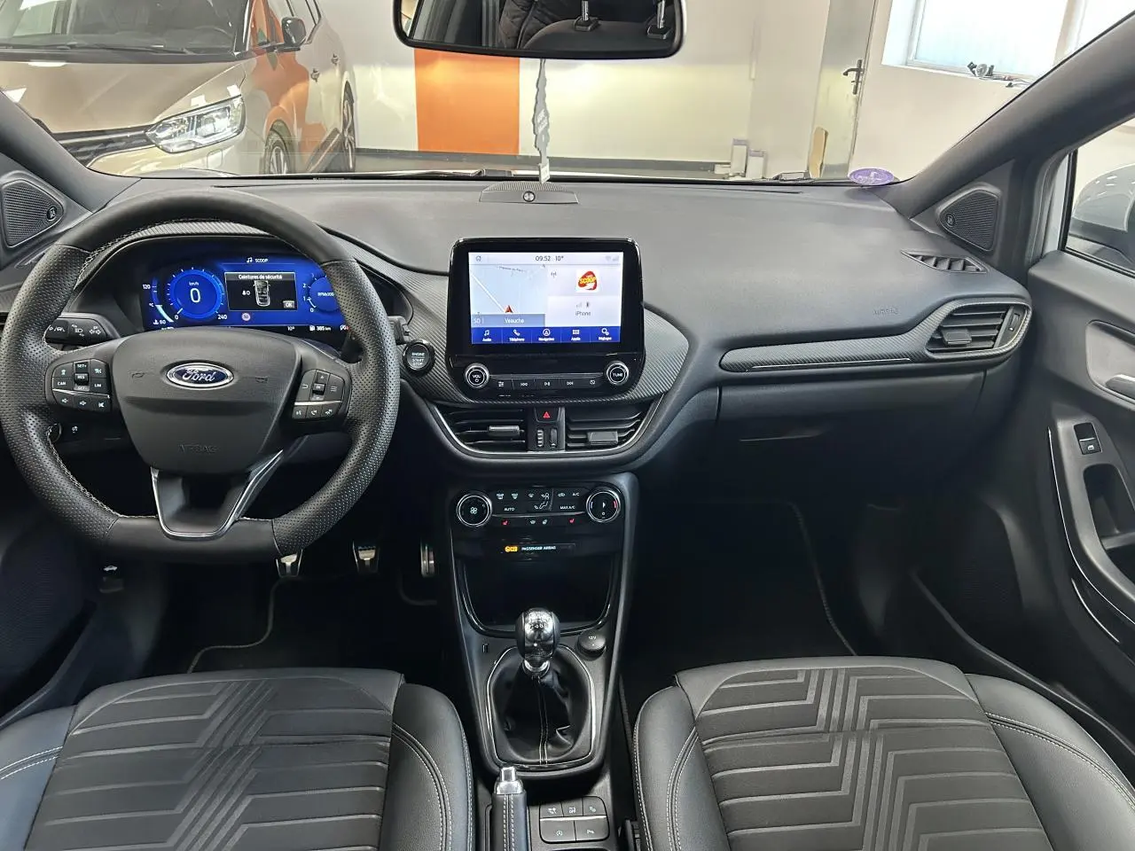 Intérieur du Ford Puma 2023, vue frontale du tableau de bord et volant avec écran tactile central allumé.