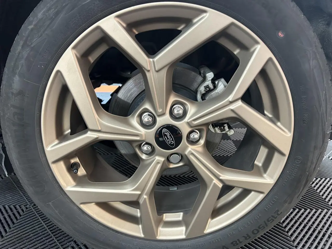 Gros plan sur la jante alliage 18 pouces finition Gold du Ford Puma gris, mettant en valeur le logo central Ford.