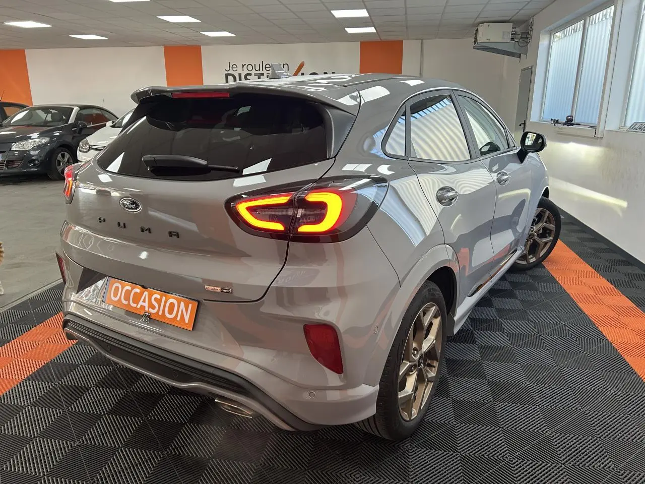 Vue 3/4 arrière droite d'une Ford Puma gris métallisé avec feux arrière LED et jantes alliage 18 pouces finition Gold.