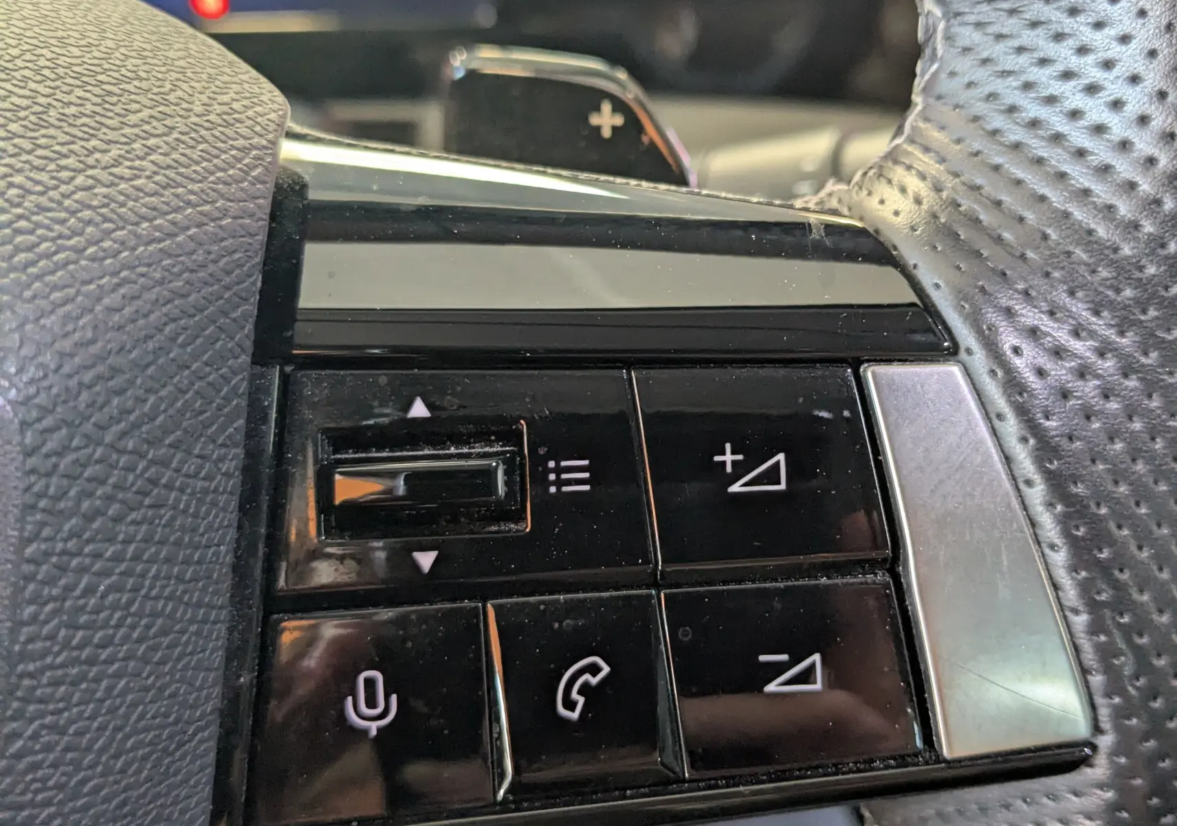 Gros plan sur les commandes noires au volant en cuir perforé de l'Opel Astra 1.5D 130ch BVA8 Elegance 2022.