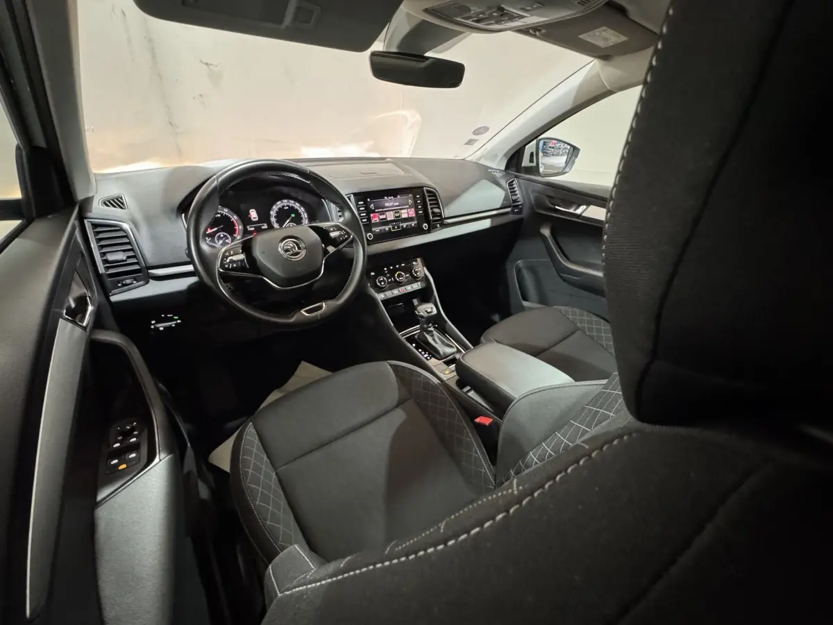 Intérieur noir du Skoda Karoq 2021 vu côté conducteur, avec tableau de bord digital et écran tactile central.