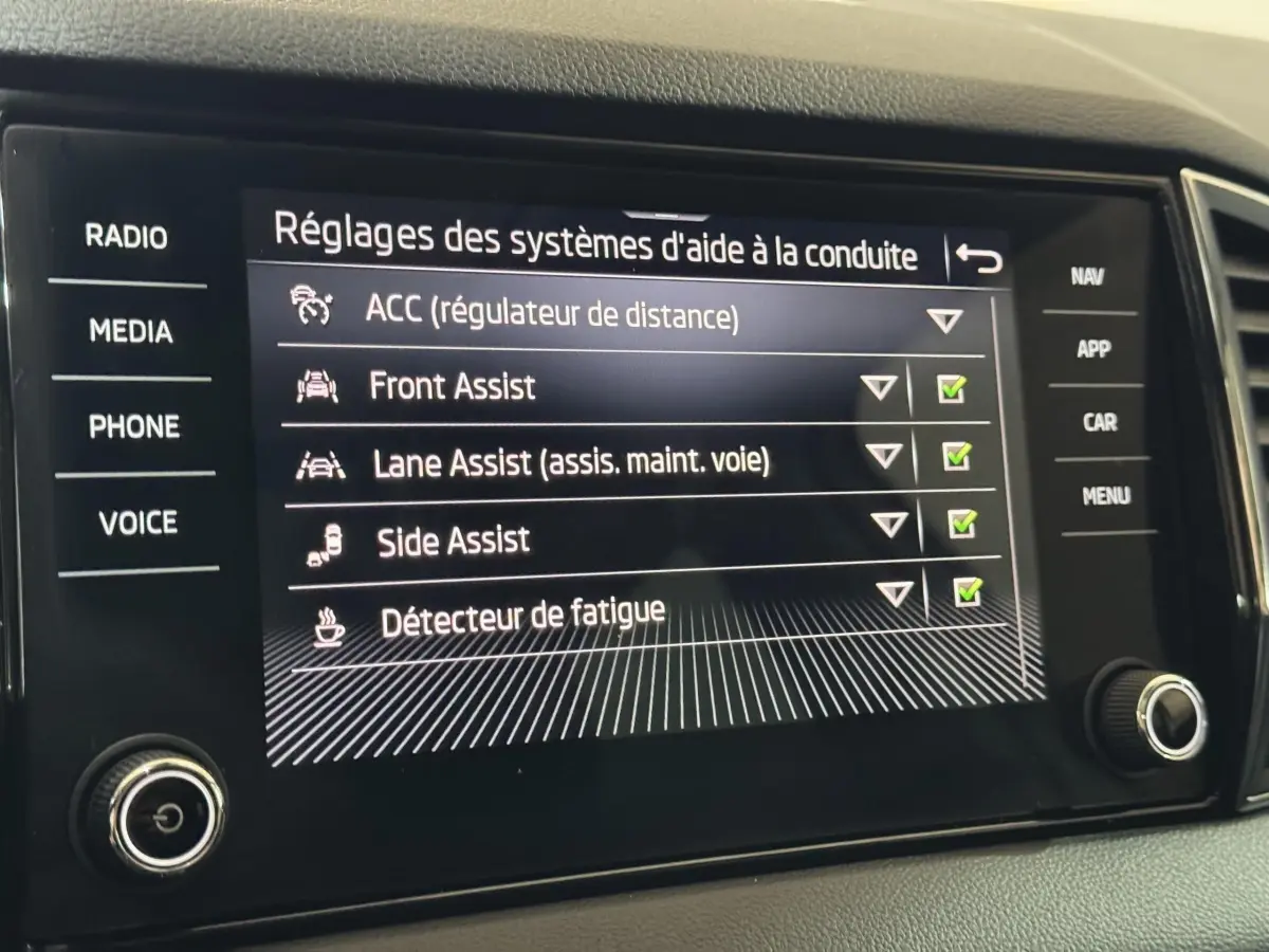 Écran tactile central du Skoda Karoq blanc 2021 affichant les réglages d'aide à la conduite