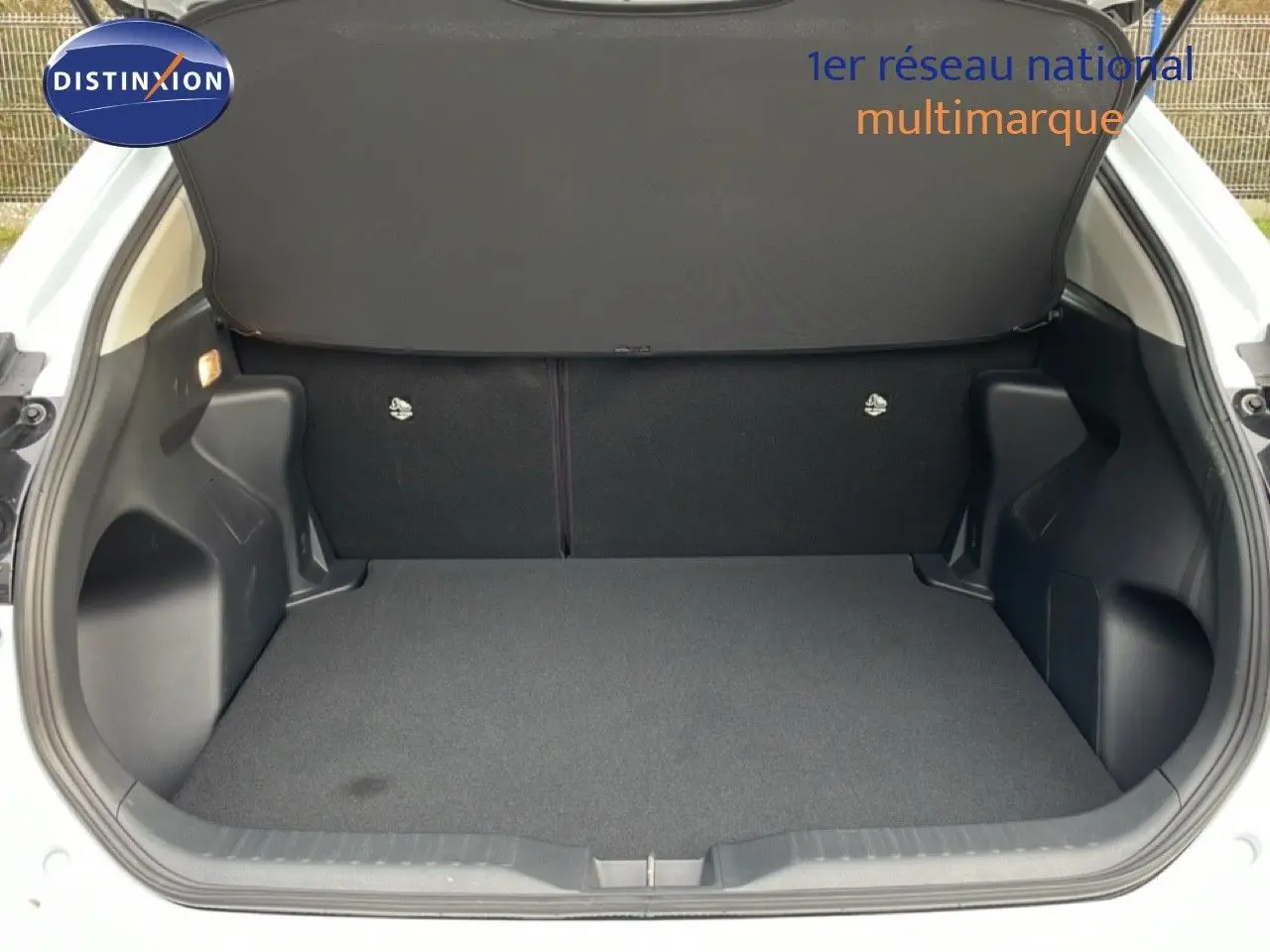 Coffre ouvert vu de l'arrière d'une Toyota Yaris Cross blanc pur, montrant un espace de chargement propre et spacieux.