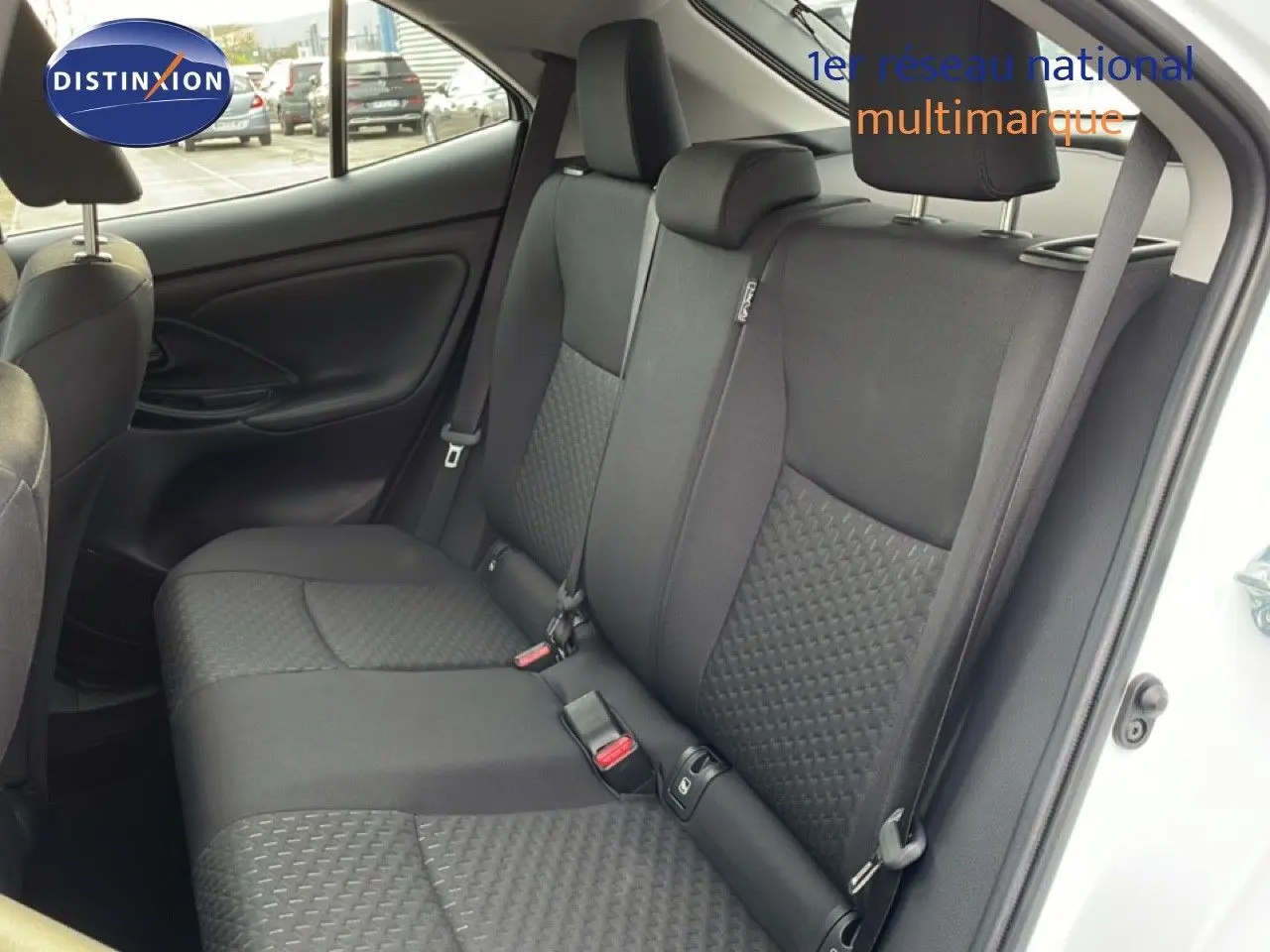 Vue intérieure côté droit montrant les sièges arrière noirs en tissu de la Toyota Yaris Cross 2024 blanche.