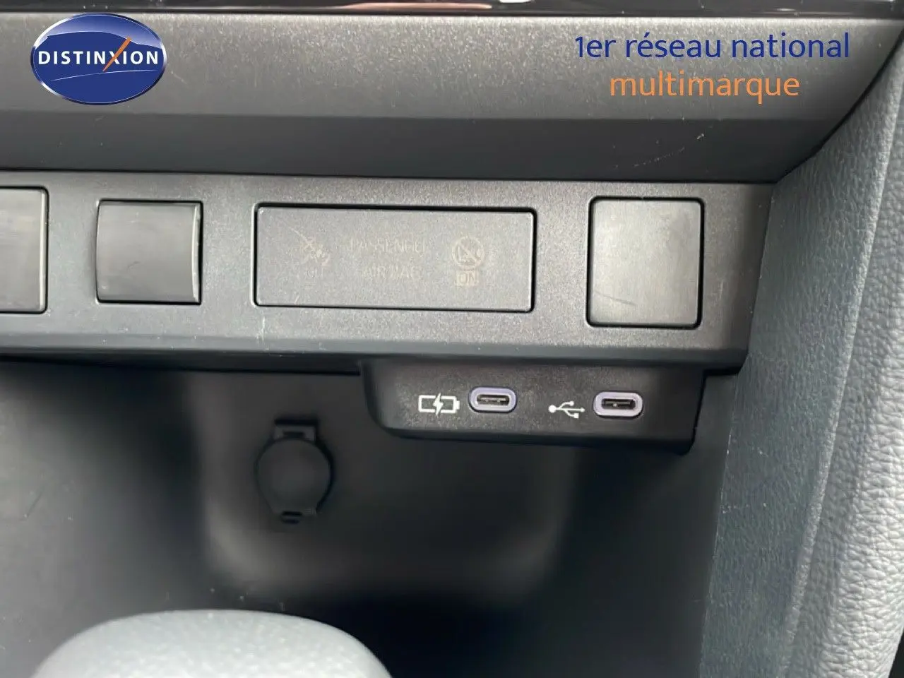 Gros plan sur les ports USB-C et prise 12V du tableau de bord noir de la Toyota Yaris Cross blanche 2024.